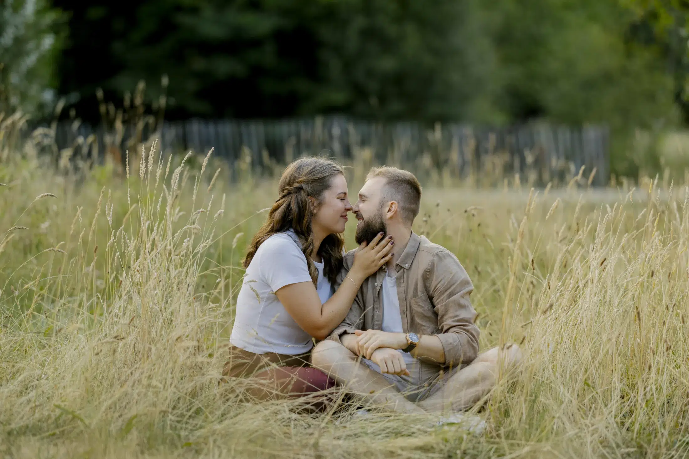 Séance photo couple en extérieur dans un champ au milieu des hautes herbes