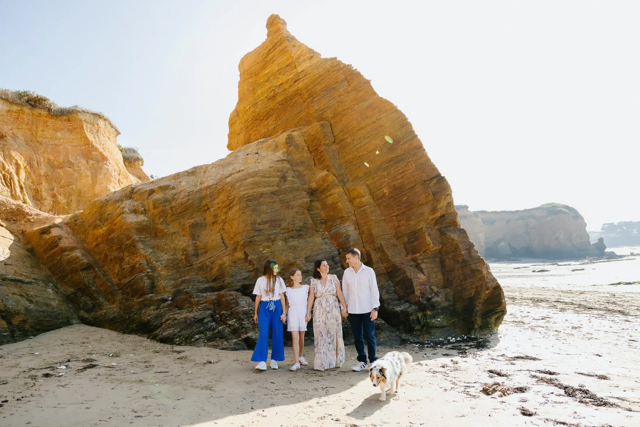 Photographe famille en Bretagne, séance photo en extérieur sur une plage avec parents, enfants et chien